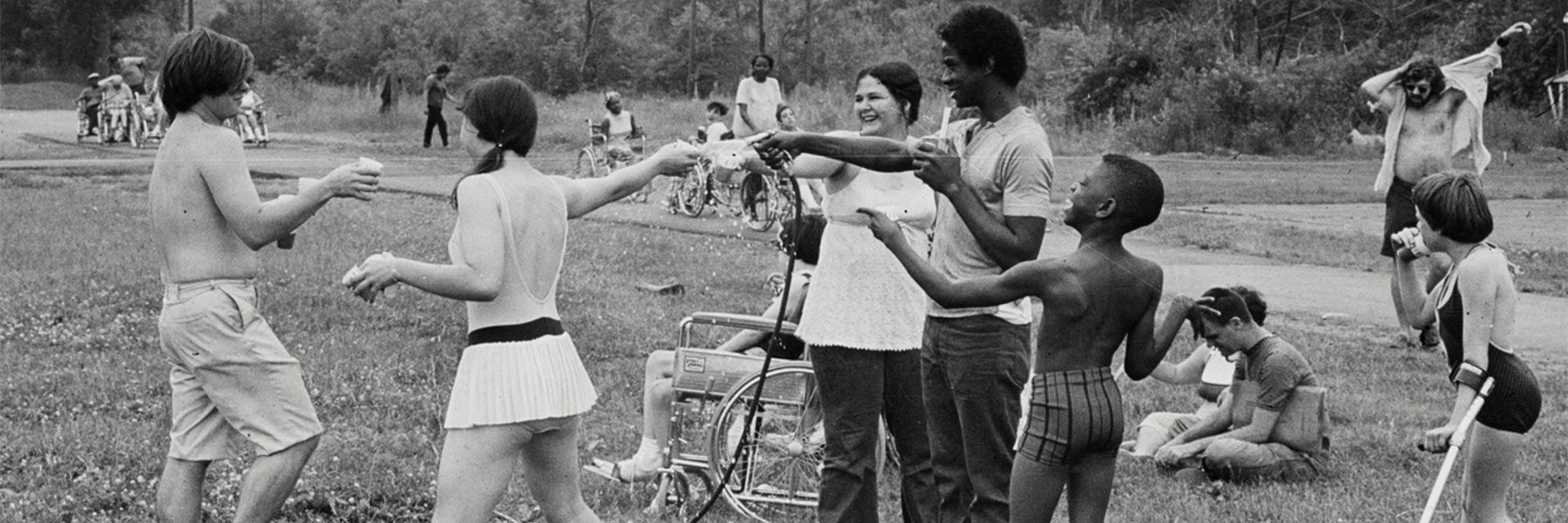 Children playing with a hose at summer camp