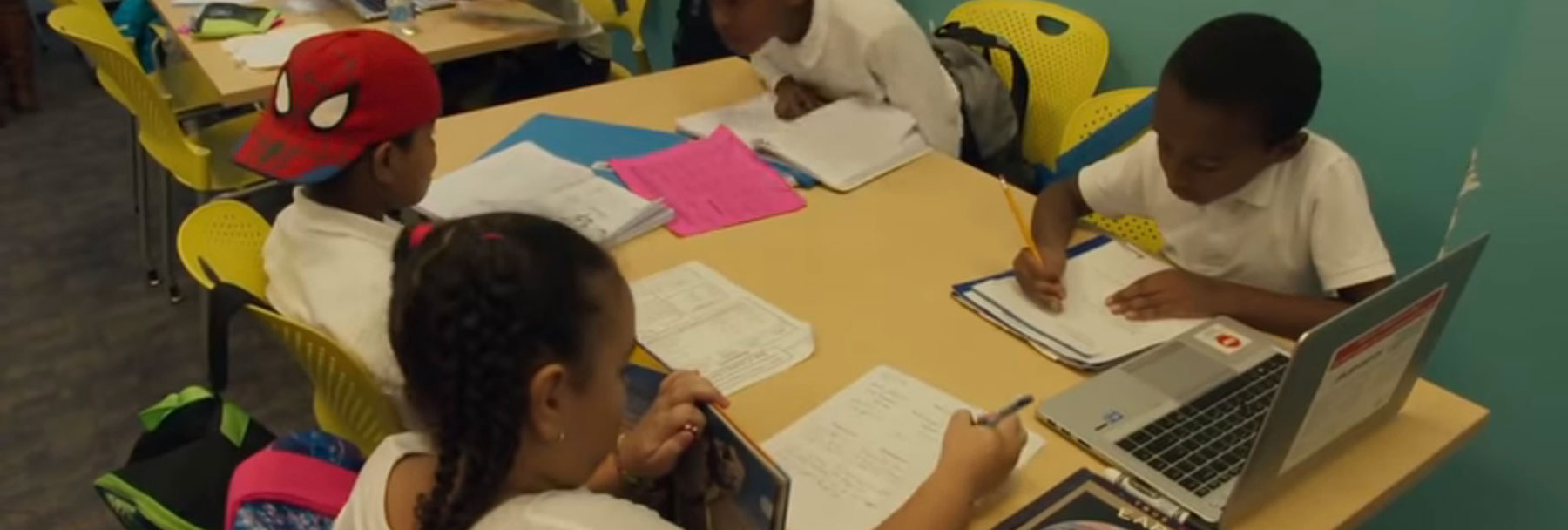 Elementary school children doing schoolwork together at a table.
